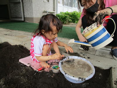 水着に着替えて、砂場にいき、水を使って泥だんご遊び