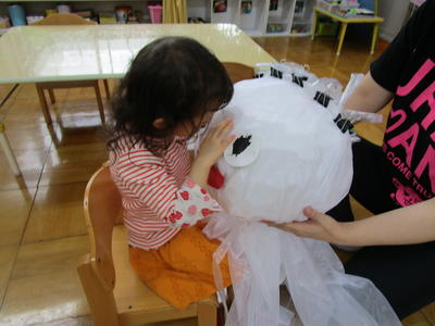 新聞紙で作ったてるてる坊主と触れあっている