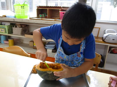 かぼちゃの種をスプーンを使って取っている