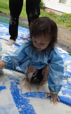 ブルーシートの上の小麦粉を触って感触を確かめながら遊んでいる。