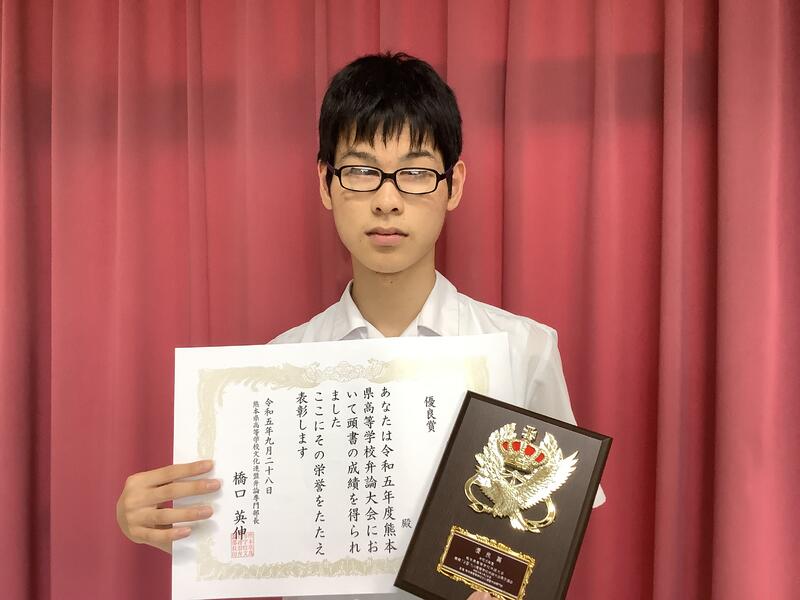 賞状と盾を持って